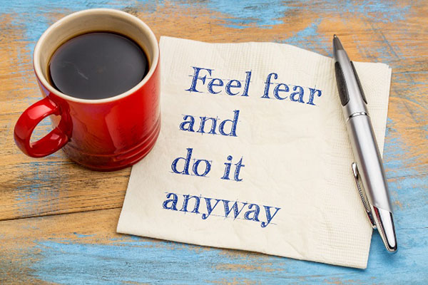 note pad with writing feel the fear and do  it anyway